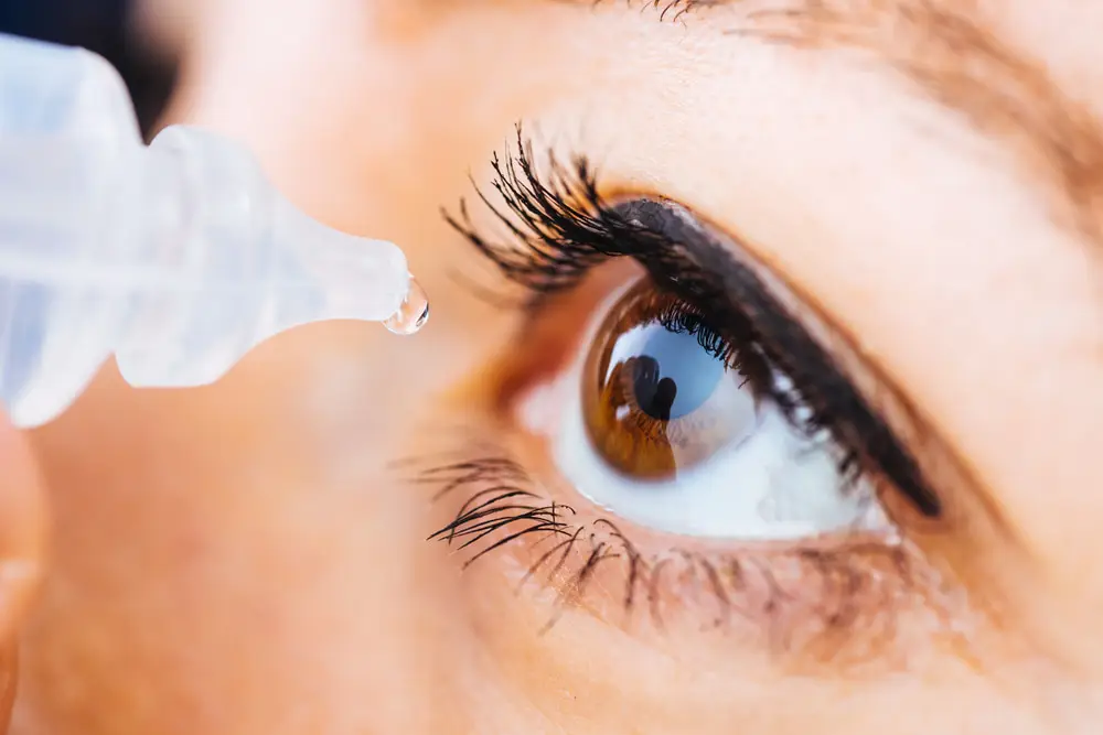 Close-up of an eye receiving lubricating drops, commonly used for dry eye relief or as part of routine eye care.